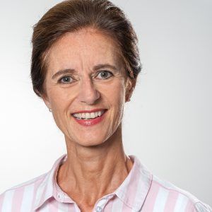Porträt von Dr. med. Claudia Ertl, lächelnd in einem rosa gestreiften Hemd