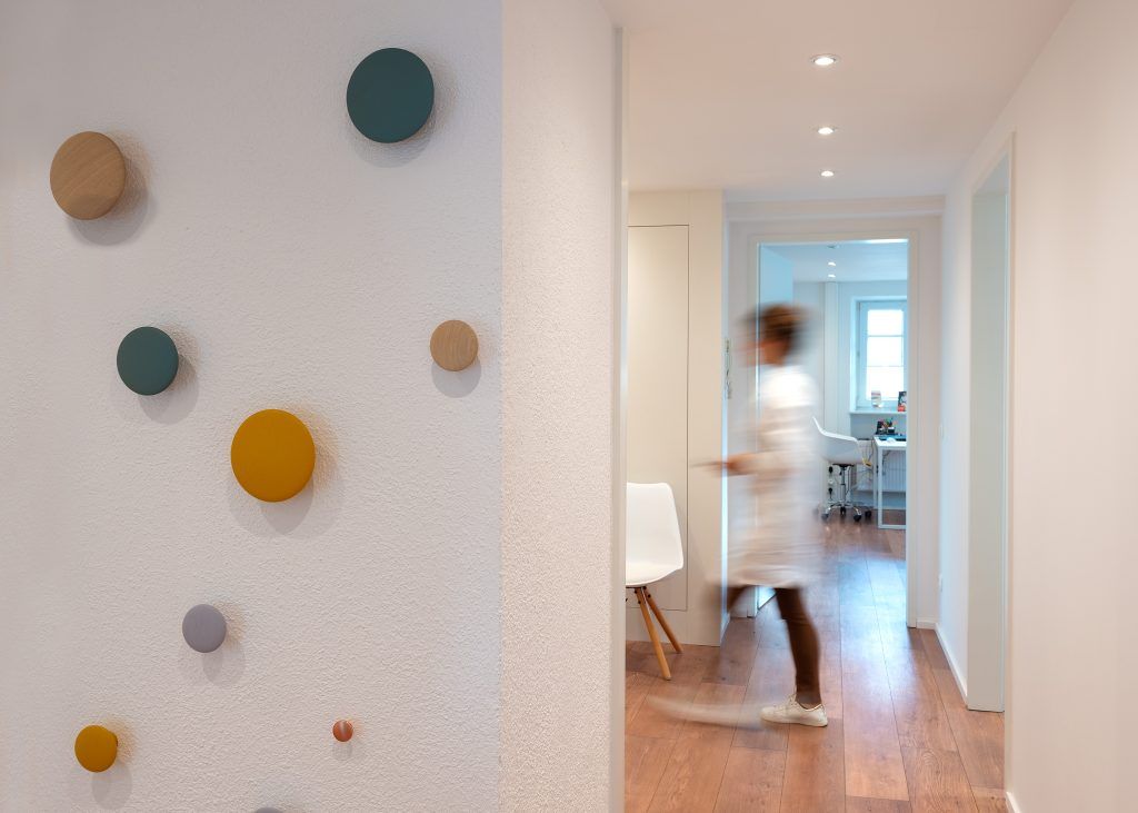 Flurbereich mit dekorativen Holzelementen an der Wand und Blick in die Sprechzimmer