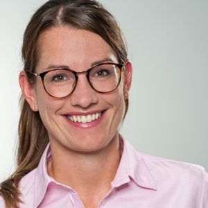 Porträt von Dr. med. Veronika Weinmann, lächelnd mit Brille in einer rosa Bluse