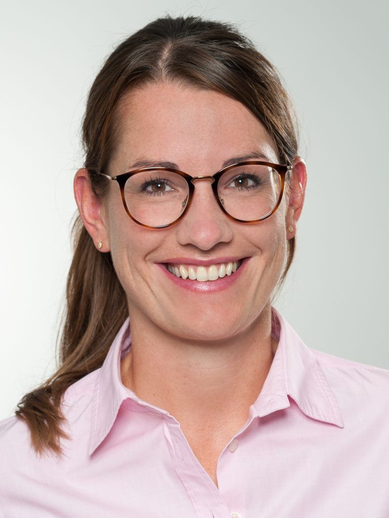 Porträt von Dr. med. Veronika Weinmann, lächelnd mit Brille in einer rosa Bluse